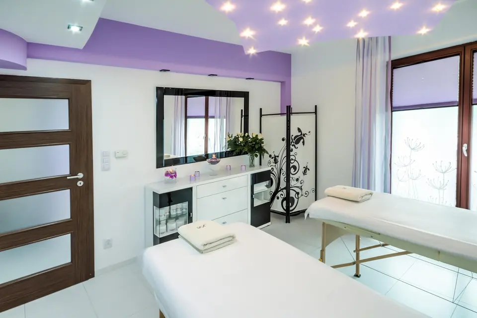 A clean aesthetic treatment room with a treatment bed