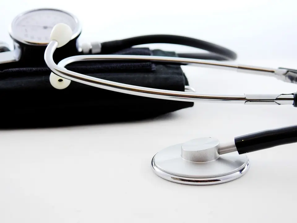 A blood pressure cuff and stethoscope on a white surface
