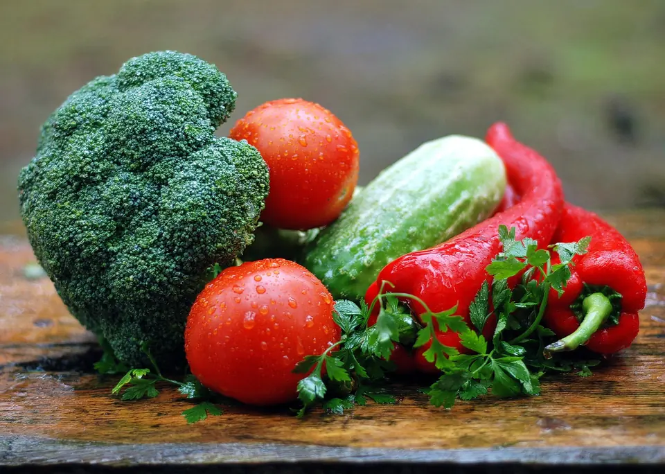 Fresh broccoli, tomatoes, cucumber and red peppers on a wooden table