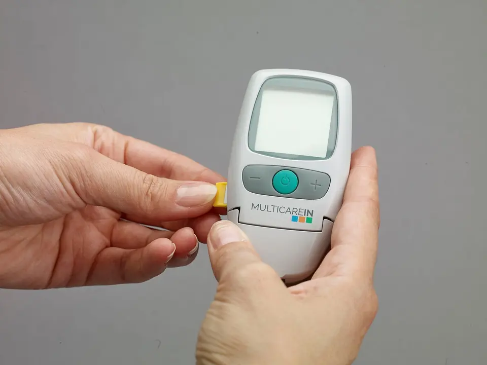 Hands using a glucometer to check blood sugar