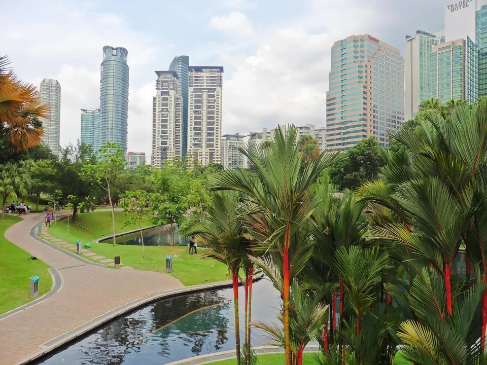 Green park in Kuala Lumpur with city towers behind