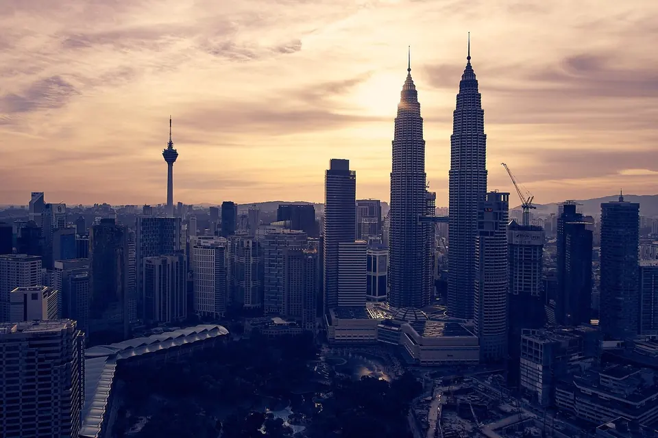 Kuala Lumpur skyline and the Petronas Twin Towers under a hazy sky at dusk